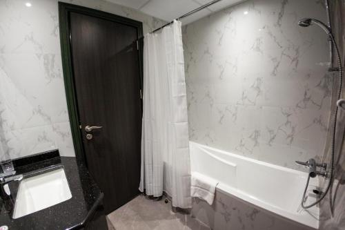 a bathroom with a shower and a white shower curtain at Cosy Studio with Canal Views by Orion Short Stays - 521 Monthly Offer in Dubai