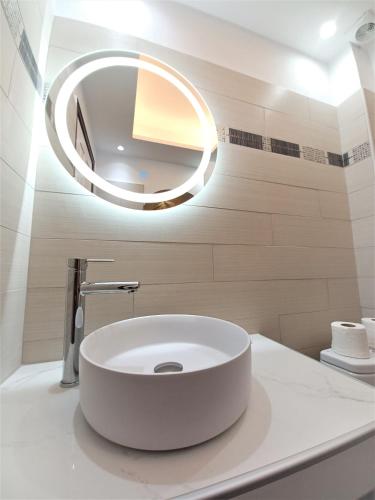 a bathroom with a white sink and a mirror at Evelina Family Beach Pension a breath away from the Black Beach offer plenty of accommodation type to suit every traveler's needs-Economic Rooms-Thematic Rooms-Design Rooms-Kitchenette Rooms-Studios-Small Apartments in Perissa