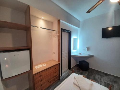 a bedroom with a bathroom with a sink and a bed at Evelina Beach Pension a breath away from the Black Beach offer private rooms&studios to suit every traveler's needs in Perissa