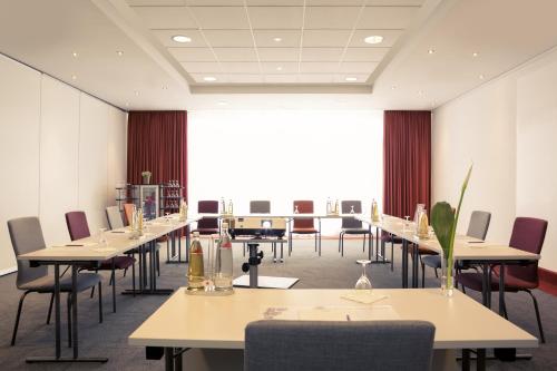 a conference room with tables and chairs and a large window at Mercure Hotel Stuttgart Airport Messe in Stuttgart
