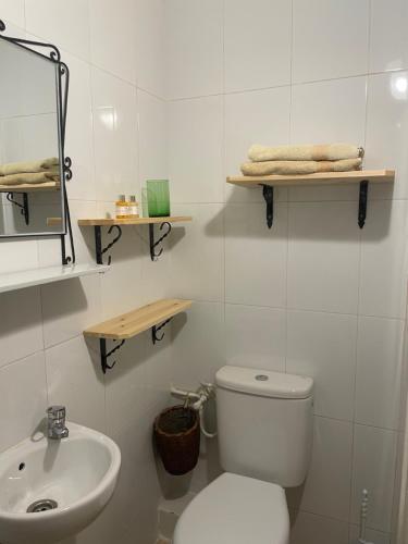 a white bathroom with a toilet and a sink at Riad Hanya in Marrakech