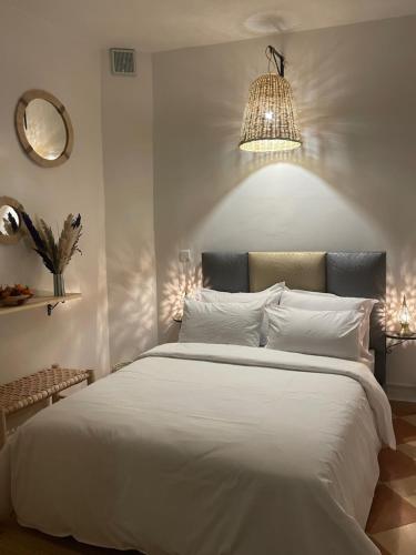 a bedroom with a large white bed with a chandelier at Riad Hanya in Marrakech