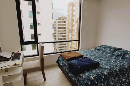 1 dormitorio con cama, escritorio y ventana en Gran apartamento familiar en Quito - Great family apartment in Quito en Quito