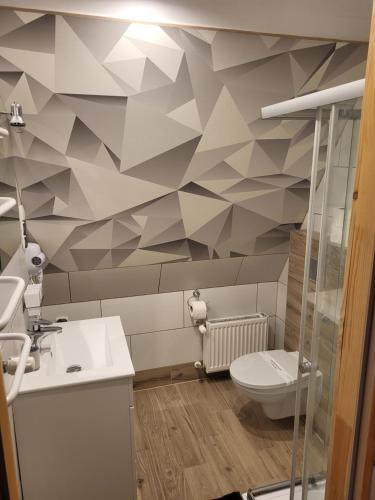 a bathroom with a geometric patterned wall at O.W.S. Strzecha in Duszniki Zdrój