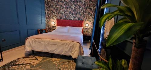 1 dormitorio con 1 cama con cabecero rojo en Boutique Suites, en Arcos de la Frontera