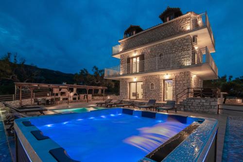 a villa with a swimming pool in front of a house at Villa Foteini in Skinária