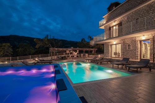 a villa with a swimming pool at night at Villa Foteini in Skinária