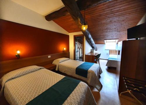 a hotel room with two beds and a television at Altavilla Albergo meublé in Tirano