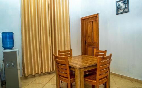comedor con mesa de madera y sillas en KUNN Apartments, en Asaba
