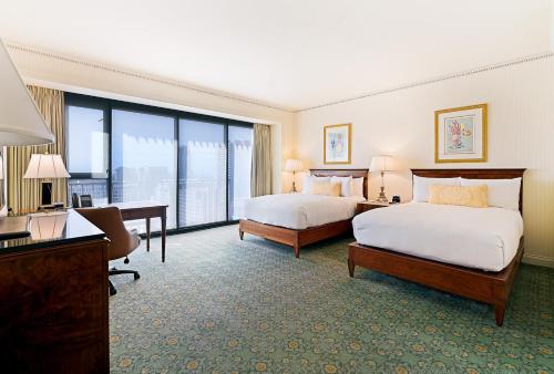 a hotel room with two beds and a desk at The Westgate Hotel in San Diego