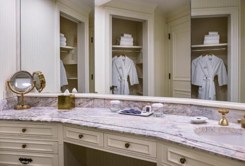 baño con lavabo y espejo grande en The Westgate Hotel, en San Diego