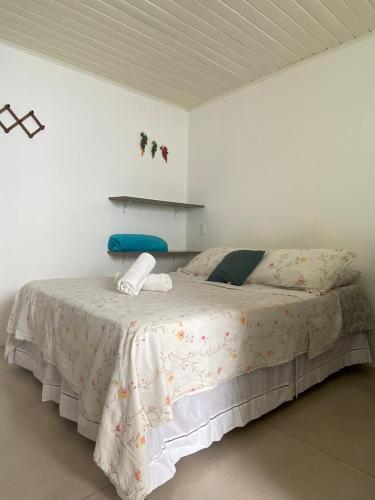 a bedroom with a large bed in a white room at SUÍTES Caminho do Mar in Abraão