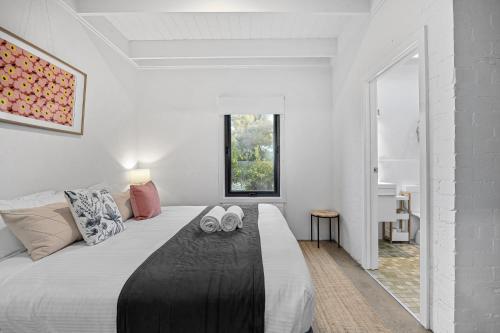 a bedroom with a large bed with slippers on it at Sorrento Beach House in Sorrento