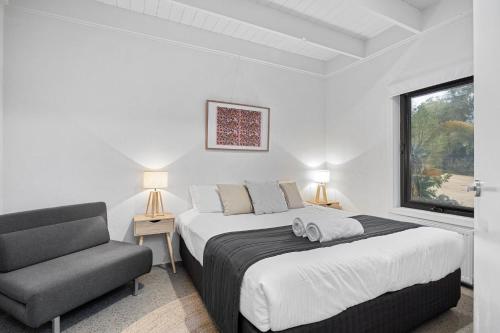 1 dormitorio con 1 cama, 1 silla y 1 ventana en Sorrento Beach House, en Sorrento