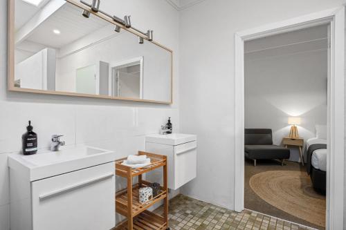 bagno bianco con lavandino e specchio di Sorrento Beach House a Sorrento