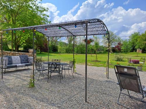 a pergola with a table and chairs in a garden at Le Passé Composé in Millau