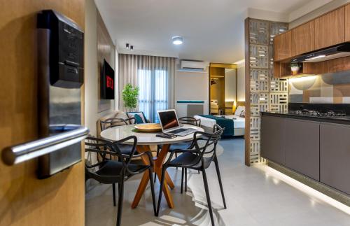 eine Küche und ein Esszimmer mit einem Tisch mit einem Laptop in der Unterkunft Flat ESPETACULAR PRAIA DE CAMBURI Long Stay in Vitória