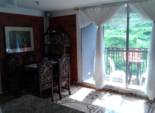 sala de estar con ventana grande, mesa y sillas en Como en casa, en Itagüí