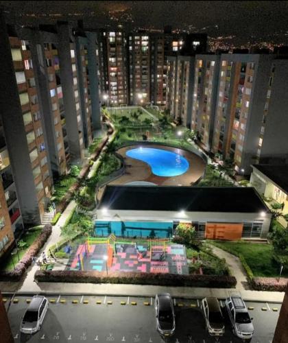 a view of a building with a pool at night at Como en casa in Itagüí