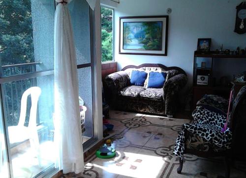 sala de estar con sofá y ventana en Como en casa, en Itagüí
