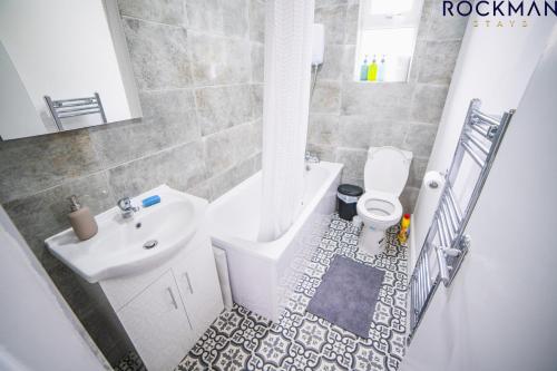 een badkamer met een wastafel, een toilet en een bad bij 12B Alexandra Street - Stylish Apartment in the Heart of Southend on Sea by Rockman Stays in Southend-on-Sea