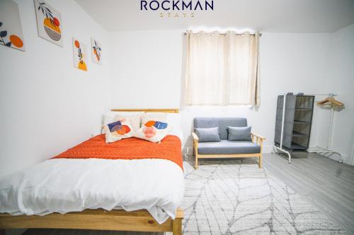 una camera con letto e sedia blu di 12D Alexandra Street - Charming Apartment in Central Southend Location by Rockman Stays a Southend-on-Sea