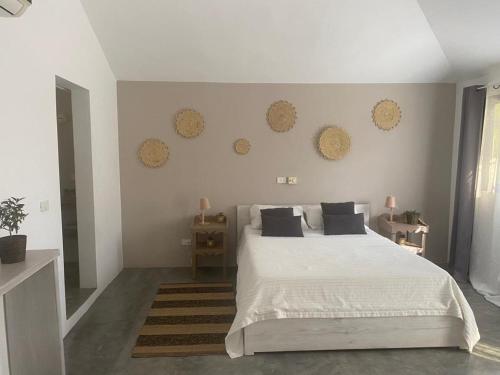a bedroom with a white bed with black pillows at La Belle Créole in Las Galeras