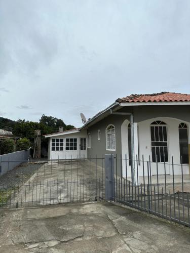 ein weißes Haus mit einem Zaun davor in der Unterkunft Casa Recanto Alegria in Urubici