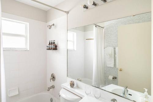 un bagno bianco con vasca, lavandino e specchio di Quiet Getaway to Tampa & Orlando a Mulberry