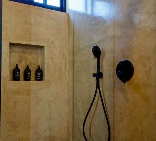 un baño con ducha y 3 botellas en la pared en Villas MG, en Valle de Guadalupe