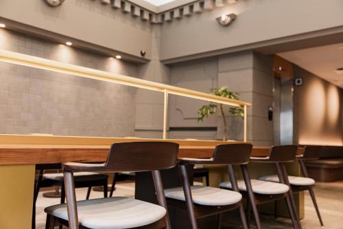 a row of chairs around a table in a room at Hotel Arthur KITAHAMA BASE in Beppu