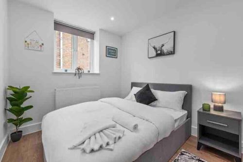 een witte slaapkamer met een groot bed en een raam bij Cozy Flat near London Eye/ Victoria / Vauxhall in Londen