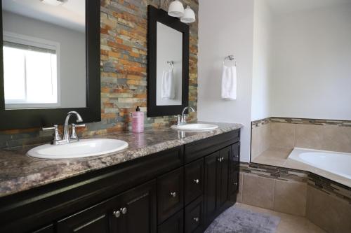 a bathroom with two sinks and a bath tub at Lavish 4BR House Near Simcoe Lake & FH Resort in Innisfil