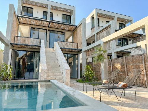 une maison avec piscine devant un immeuble dans l'établissement Villa Toh, à Tulum