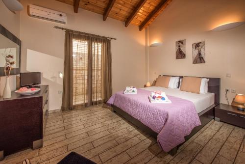 a bedroom with a large bed with a purple blanket at Astarte Villas - Kyveli Luxurious Private Villa in Zakynthos Town