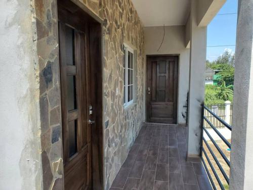 eine Tür zu einem Haus mit einer Steinmauer und einer Veranda in der Unterkunft Apartamentos y Hostal Rudon # 5 in Puerto Cortes