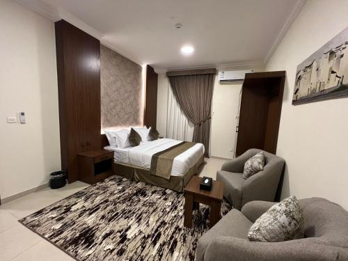 a hotel room with a bed and two chairs at سمو سويت للشقق المخدومة 2 Smo Suites in Riyadh