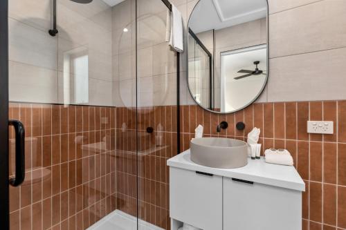 a bathroom with a sink and a shower with a mirror at BIG4 Bendigo Park Lane Holiday Park in Bendigo