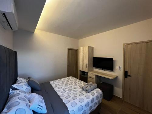 a bedroom with a bed and a flat screen tv at Habitación Cerezo en Palmerola, Comayagua in Comayagua