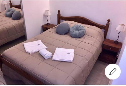 una camera da letto con un letto con cuscini blu di Hermoso Monoambiente en el centro de Comodoro Rivadavia a Comodoro Rivadavia