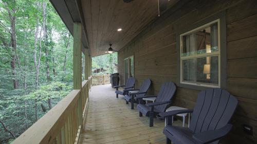 a row of chairs on the porch of a house at NEW! Murphy*Hot Tub*Fire Pit in Murphy