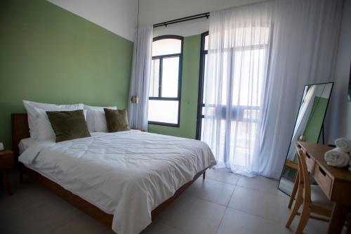 a bedroom with a bed and a large window at GOLANI8 in Haifa