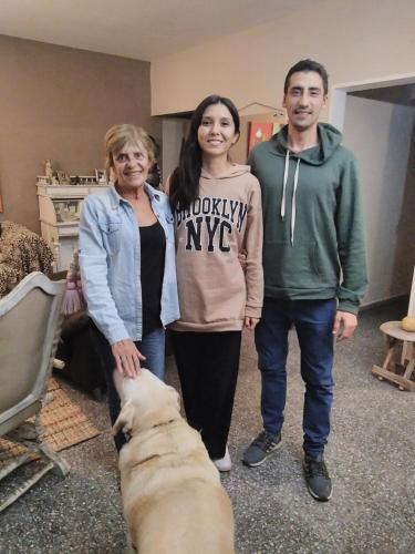 three people standing next to a dog in a room at Mi Lugar en el Mundo in Buenos Aires