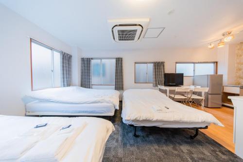 a hotel room with two beds and a desk at Tokyo SA Ryokan in Tokyo
