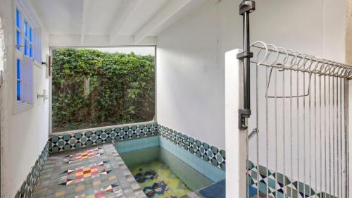 a bathroom with a shower with a pool of water at Beachside Bliss - Waiwera Beachfront Holiday Home in Orewa
