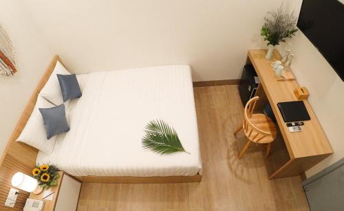a small bedroom with a white bed and a desk at Vy's House Phanthiet Hotel in Ấp Tân An (1)