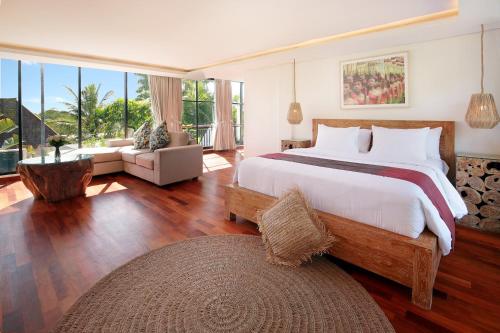 een slaapkamer met een groot bed en een groot raam bij Kandahill Bali in Uluwatu