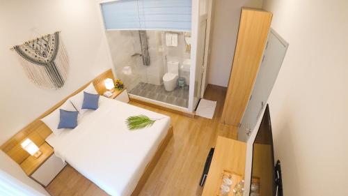 a small room with a white bed and a bathroom at Vy's House Phanthiet Hotel in Ấp Tân An (1)