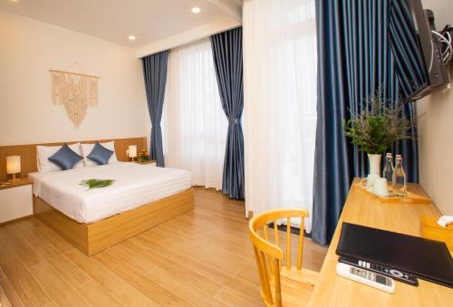a hotel room with a bed and a desk at Vy's House Phanthiet Hotel in Ấp Tân An (1)