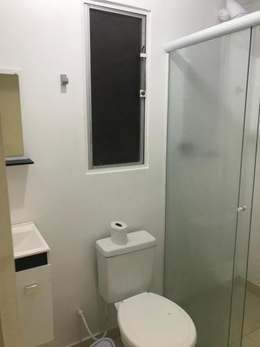 uma casa de banho com um WC e uma cabina de duche em vidro. em Kitinete em Chapecó